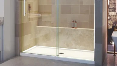 Modern walk-in shower with beige tile and glass door. Minimalist bathroom design.