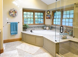 Bright bathroom with a corner bathtub surrounded by large windows and a glass shower enclosure.
