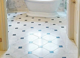 Bathroom floor with white marble and dark square tile pattern.