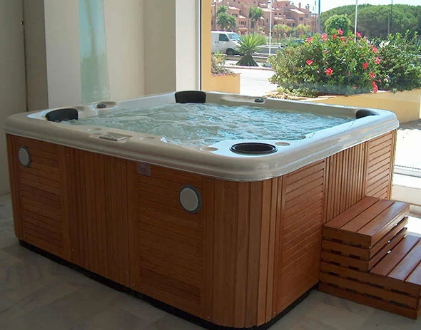 Hot tub with wooden panels and steps, filled with bubbling water, ready for relaxation.