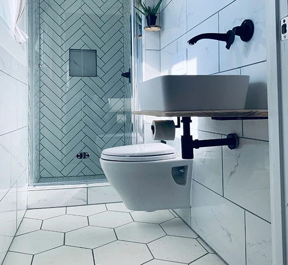 Bathroom featuring custom shower tiling, floating toilet and sink, and hexagonal floor tiles.