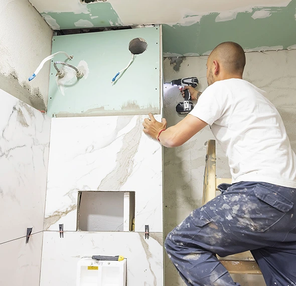 Worker installing tile during full-service remodel.
