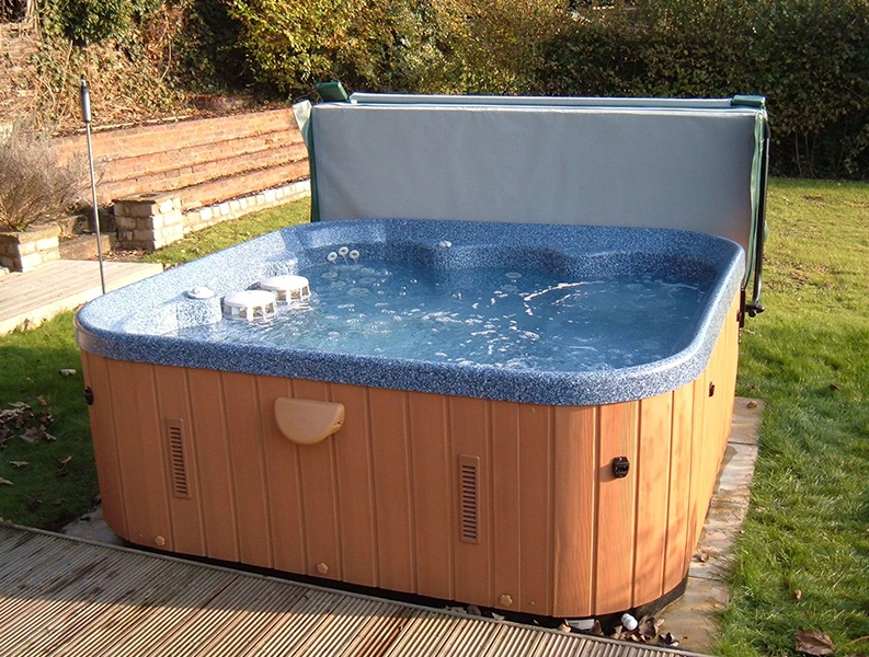 Outdoor hot tub with cover partially open, ready for relaxation.