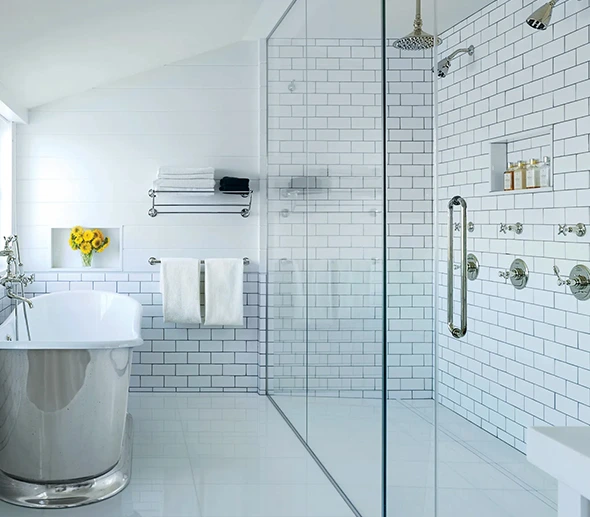 modern bathroom with subway tile, freestanding tub, and glass-enclosed shower.