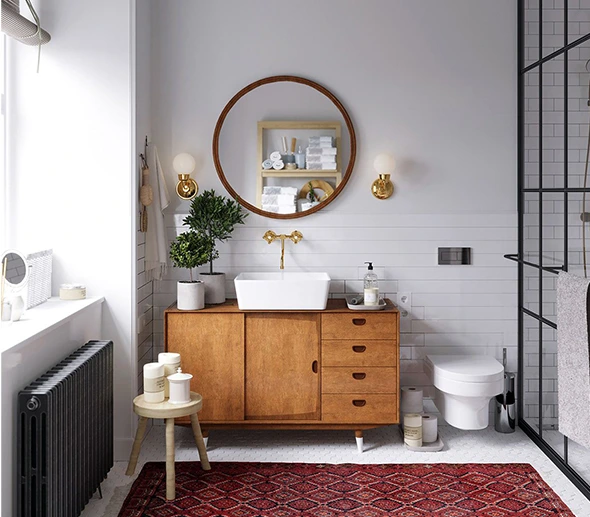 Bathroom featuring a wood vanity, round mirror, white sink, and red rug. Bathroom Vanity Installation.