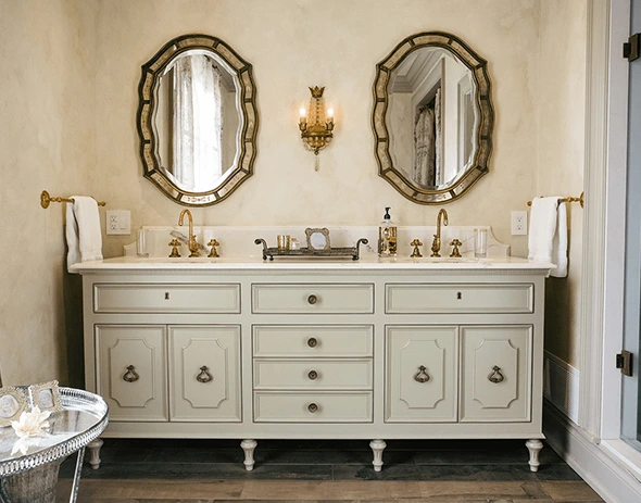 Luxury bathroom vanity with double sinks, ornate mirrors, and gold fixtures.