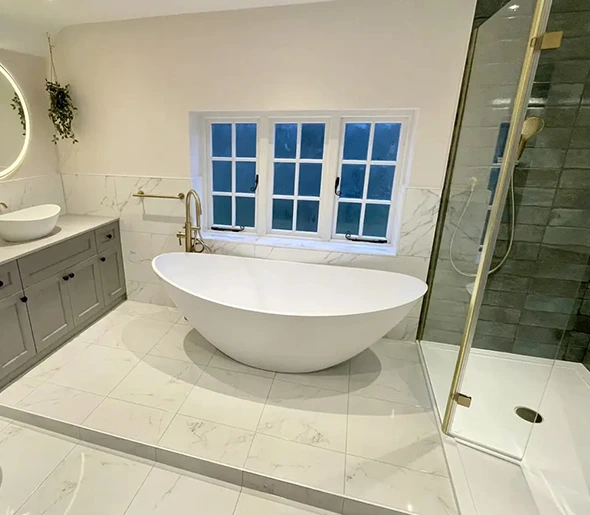 Modern bathroom with freestanding tub, marble tile, and walk-in shower.