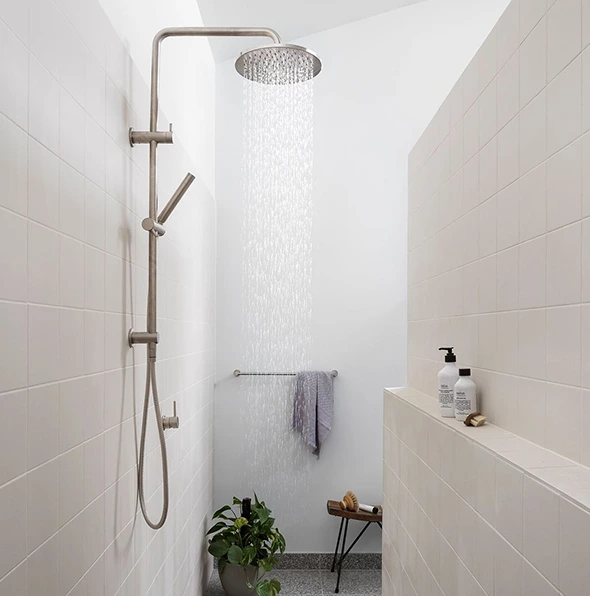 Modern bathroom shower with rainfall showerhead, hand shower, and white tile walls.