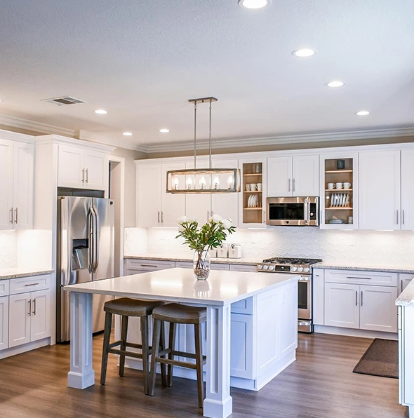 Luxury kitchen remodel with white cabinets, island, and stainless steel appliances.