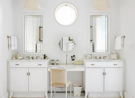 Bright bathroom with custom bathroom cabinets, vanity, and round mirrors.